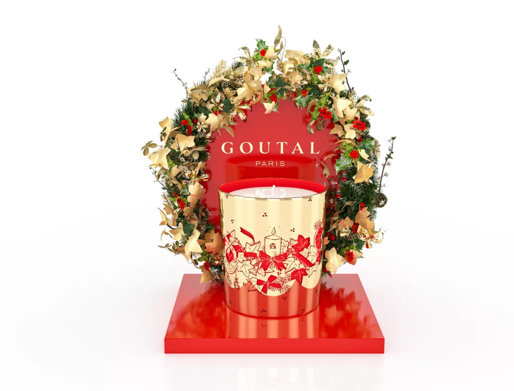 Présentoir 3D retail Goutal rouge brillant avec couronne de lierre doré et bougie de Noël sur plateau ovale or.